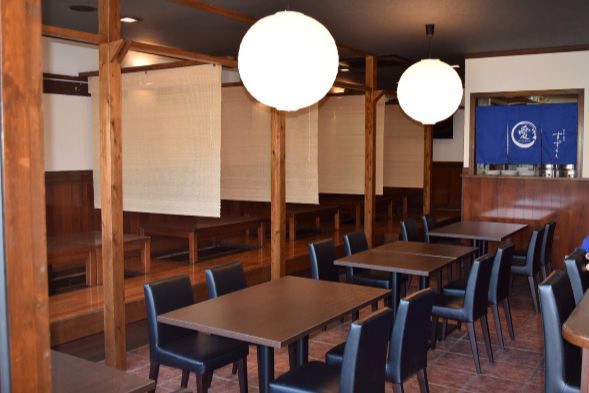 テーブル席と青い暖簾が見える店内
